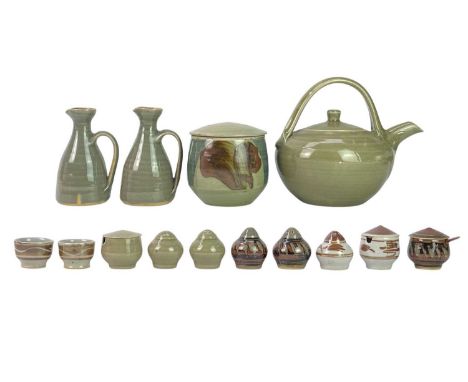 A collection of fourteen Crowan Pottery pieces. One teapot, one large lidded jar, two jugs, two pairs of salt and pepper shak