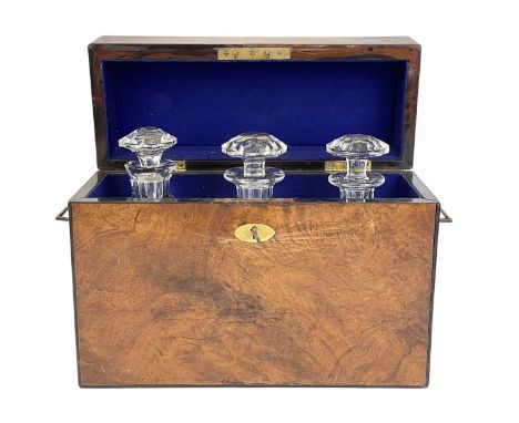 A Victorian figured walnut campaign style tantalus. With folding brass side handles and fitted with three square glass decant
