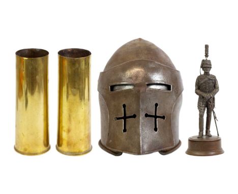 A reproduction polished steel Barbuta style helmet. With a hinged visor, length 32cm, together with two brass shell cases, an