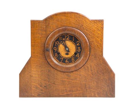 An Arts and Crafts oak mantel clock. Circa 1920, with an ebony and boxwood inlaid dial, fitted a German movement, height 28cm