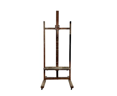 An oak adjustable artist's easel. Circa 1920, with plain supports, on casters, the action adjusted with a lever device.