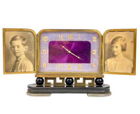 A Swiss Art Deco stylish timepiece. With two gilt metal doors revealing the enamelled dial, raised on an engraved Greek Key b