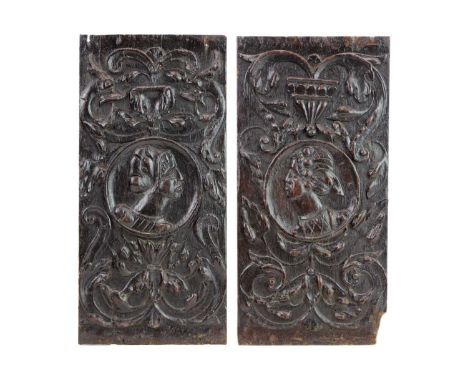 A pair of 16th century carved oak Romayne panels.  Circa 1540, each with a portrait roundel within carved swags and scrolls, 