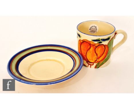 Clarice Cliff - Orange Lily - A Tankard shape coffee can and saucer circa 1929, hand painted with a stylised flower and folia