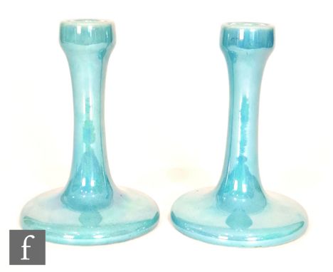 Ruskin Pottery - A pair of candlesticks of typical form decorated in an all over blue lustre, impressed mark and both dated 1