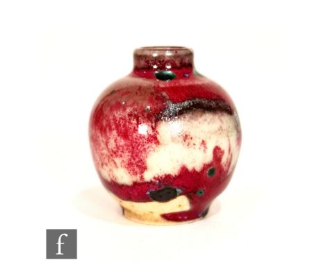 Ruskin Pottery - A miniature high fired vase of globular form with a cylinder neck, the whole decorated in a flambe glaze wit