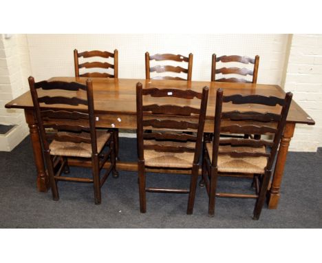 A Jacobean style oak refectory dining table, the planked, cleated top on pegged, turned and block supports united by a H stre