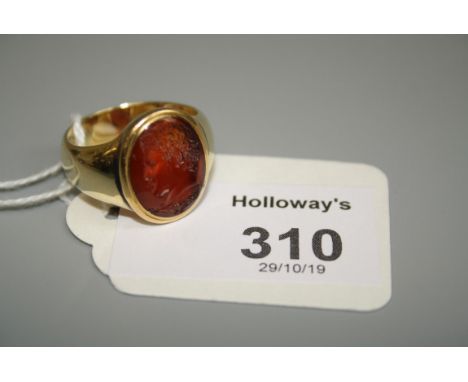 A carnelian signet ring, with an oval intaglio of a gentleman bust portrait to centre, in yellow metal mount to tapering wide