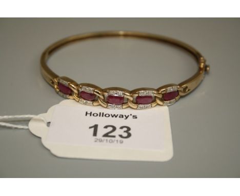 A ruby and diamond bangle, the five oval cut rubies in diamond set cable link mount Gross weight 11.9g