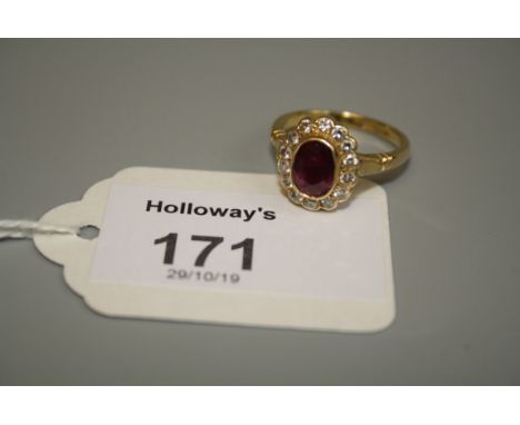 A ruby and diamond cluster ring, the old cut ruby in rub over mount, to a border of brilliant cut diamonds, the whole in 18ct