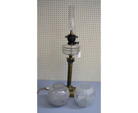 An Edwardian brass Corinthian column paraffin lamp, converted for electricity, with two spherical frosted glass shades