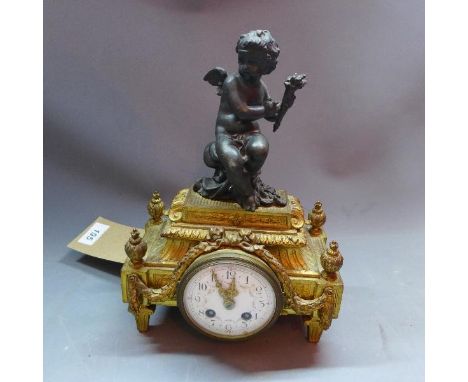 A late 19th century French ormolu and cast metal mounted mantle clock, drum movement, the white enamel dial with Arabic numer