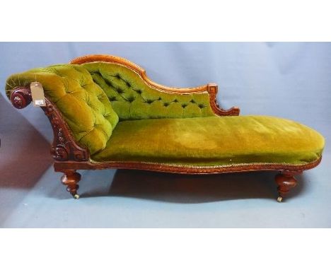 A Victorian mahogany swan back chaise longue, with green velour button back upholstery, raised on turned legs and castors 