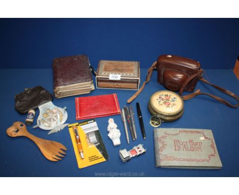 A leather cased Prakli camera, a wooden fork having elephant carving, an AA badge, old photo album, small postcard album, Par