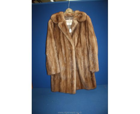 A 3/4 length Regency light brown fur coat.