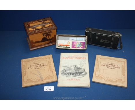 Three cigarette Card albums, box of loose cigarette cards, novelty cigarette dispenser and an old Agfa camera.