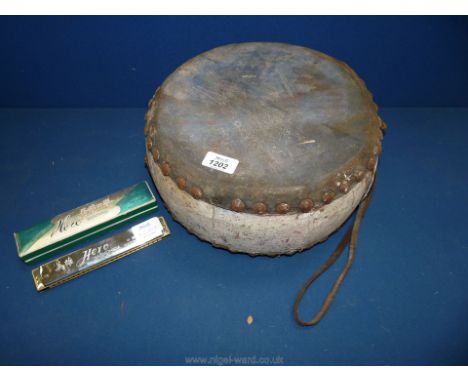 A double sided skin drum and a boxed harmonica.