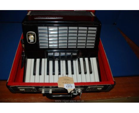 A cased Weltmeister Stella Accordion and music.