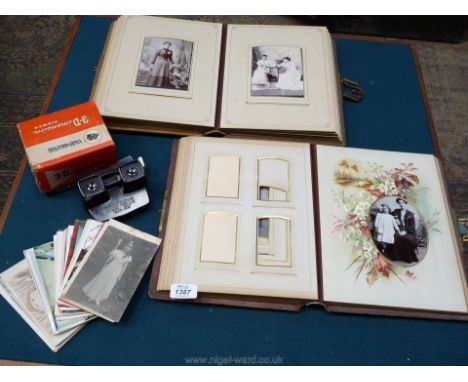 Two old photograph albums one having a brass clasp, one having a broken clasp, together with old postcards, a boxed View Mast