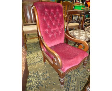 A circa 1900 button back Mahogany framed open armed Armchair having elegant scroll arms, turned front legs and upholstered in