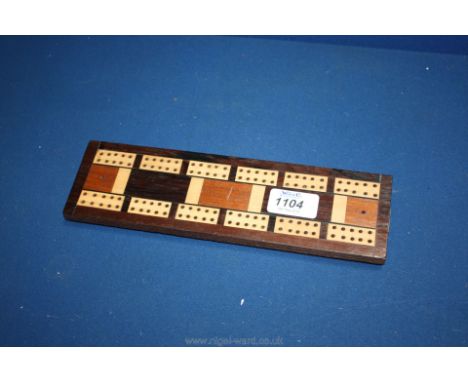 An early 20th c. cribbage board inlaid with boxwood on bun feet.
