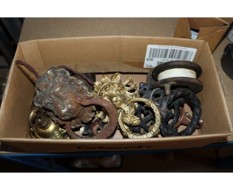 A box containing various vintage metal ware to include lion motif door knockers, cast iron door handles, vintage wooden fishi