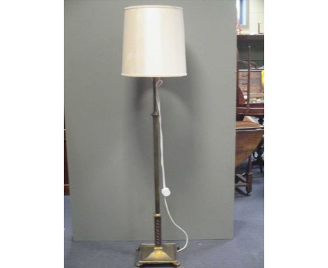A brass lamp standard and a spinning wheel