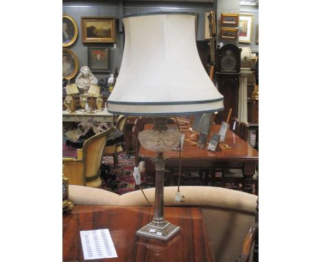 A plated Corinthian column and cut glass oil lamp, fitted for electricity, 59cm high; together with a pair of plated oil lmap