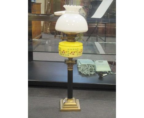 An oil lamp with yellow glass reservoir