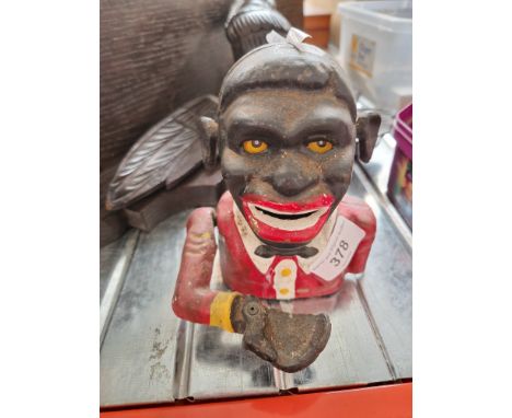 A cast metal money box.Note:- These items are listed on the basis they are illustrative of a bygone culture in which there we