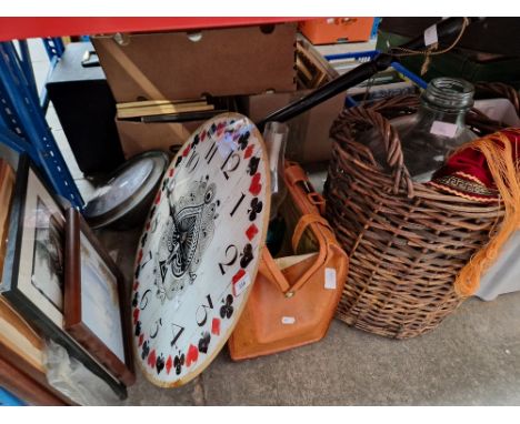 A glass carboy in wicker basket, a leather briefcase with a paraffin lamp, brass warming pan, a metal clock and a bundle of p