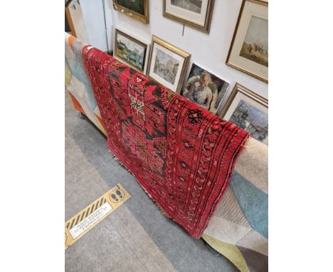 A vintage Middle Eastern wool carpet, red ground, 188cm x 104cm (approx).