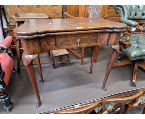 A George II walnut and oak concertina-action card table, the interior playing surface having burr yew wood dishes to the corn