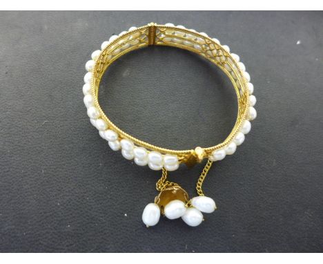 A yellow gold - presumed high carat, bracelets with two rows of pearls around circumference, safety chain terminating in pear