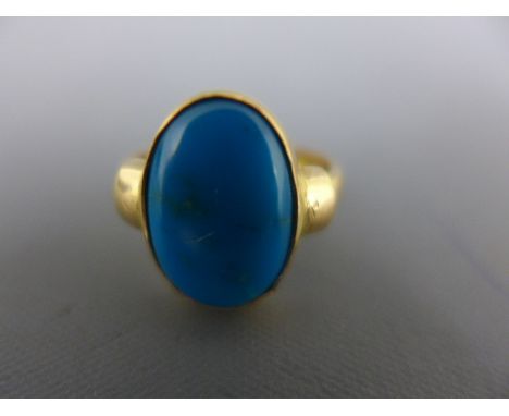 An Egyptian yellow gold ring, presumed high carat set with an oval shaped blue stone to shoulder, size K - Gross weight appro