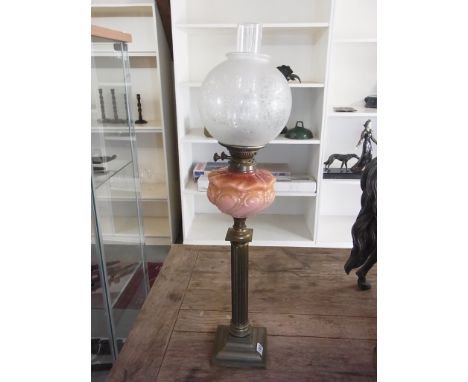 A brass oil lamp with a coloured reservoir and etched effect globe shade - Height 83cm - reasonably good condition, base dril