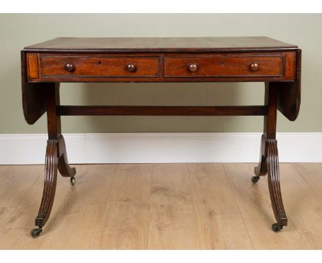 A George III mahogany sofa table with two frieze drawers, plain ends supports united by a possibly later stretcher, on reeded