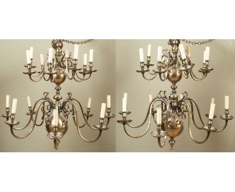 A pair of Dutch-style two-tier twelve-light brass chandeliers with scrolling branches, each approximately 90cm wide x 106cm h