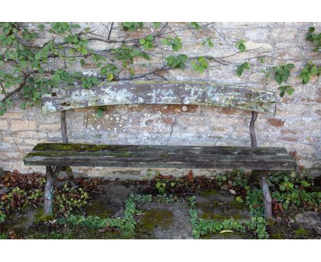 An antique garden bench with cast iron naturalistically moulded supports and an arching back, 188.5cm wide x 90cm highThe arc