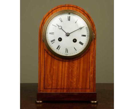 A late 19th/early 20th century satinwood mantle clock, the arching case with decorative stringing and rosewood plinth, and al