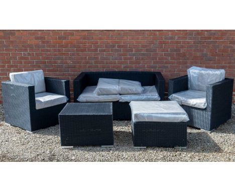 A contemporary five piece black woven garden furniture suite consisting of a two seater sofa, two armchairs, a footstool and 