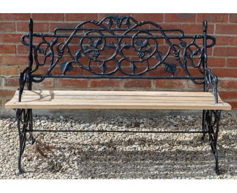A cast iron garden bench with a wooden slatted seat, back decorated with vine and grape detailing, 122cm wide x 81cm high app
