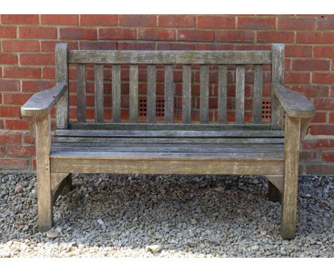 A small teak garden bench, 134cm wide x 86.5cm highWeathered overall. Seemingly structurally sound.