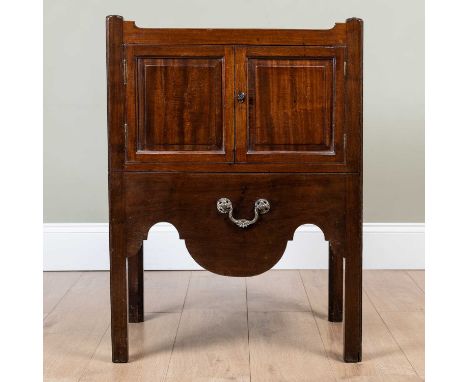 A George III mahogany pot cupboard with galleried top over twin panelled doors and pull out commode drawer, with shaped apron