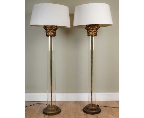 A pair of contemporary lamp standards in the form of classical columns, with gold painted capitals and bases, and glass shaft