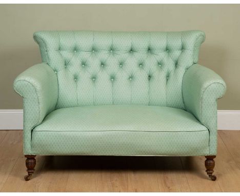 A small green button back sofa, with scrolling arms, turned tapering walnut front legs and ceramic casters, 135cm wide x 70cm