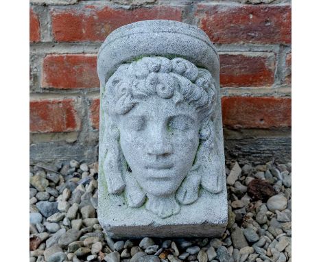 A cast reconstituted stone corbel decorated with female classical mask, 17cm wide x 27cm deep x 24cm highIn weathered conditi