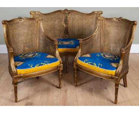 A 20th century gilt Berger suite consisting of a two seater sofa and two chairs, all with double caned backs and sides, stand