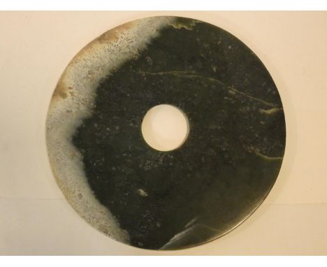 A Chinese jade disk with pierced circular central section. 31x31cm 
