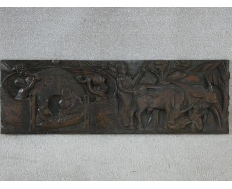 A carved African hardwood panel, farmers and cattle in a village setting, indistinctly signed to the reverse. H.33xW.100cm 
